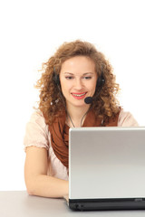 Naklejka premium A young woman with a headset working on a laptop