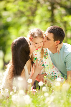 Happy mother, father and daughter in the park