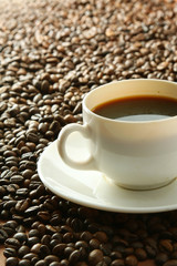 Cup of coffee on coffee grains