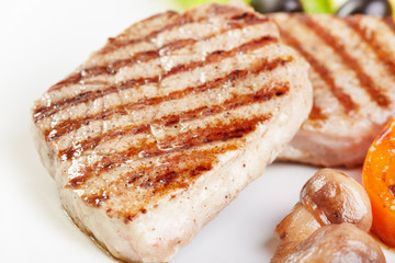 Grilled steak on white plate closeup