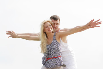 Fototapeta na wymiar young happy couple isolated on sky background