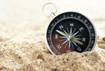 compass on the sea sand and place for text