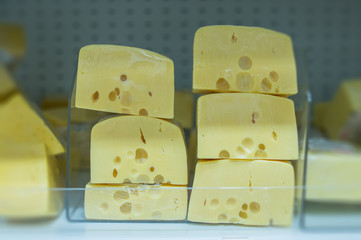 Variety of cheeses  pieces on shelves in supermarket
