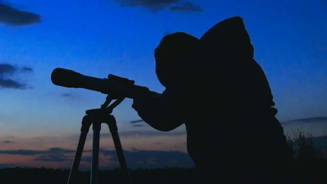 silhouette of telescope and astronomer