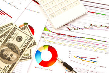 Pen ,calculator and dollars on financial Graphs