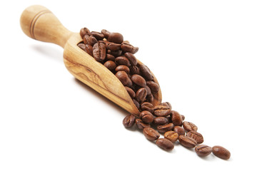 Obraz premium Coffee beans poured from wooden scoop