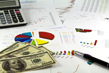 Graph down ,calculator and dollars on table