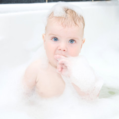 Cute baby boy washing hair hair and body in bath