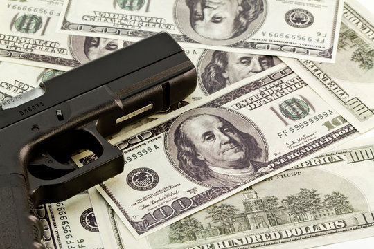 close up image of pistol and dollar
