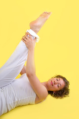 Frau beim Yoga mit gelbem Hintergrund