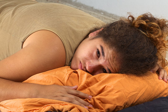 Sad Peruvian woman lying on the floor on a sleeping bag