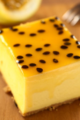 Fresh passion fruit cheesecake dessert on wooden board