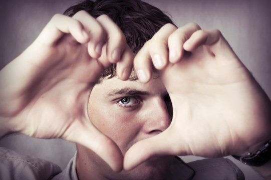 Attractive young man show love sign