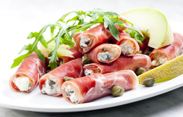 Parma ham rolls filled with cream cheese, Galia melon and capers