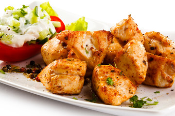Grilled meat and vegetables on white background
