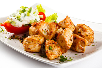 Grilled meat and vegetables on white background