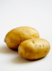 bunch of potatoes on white background close up shoot