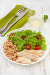 boiled chicken with beans and salad on the plate