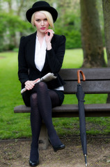 Pretty young business woman sat on bench