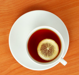 tea cup with lemon on wooden table from above
