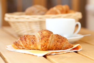 Fresh croissant and white cup coffee,