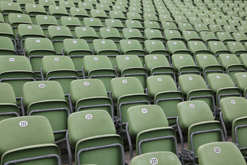 Rows of green football stadium seats with numbers