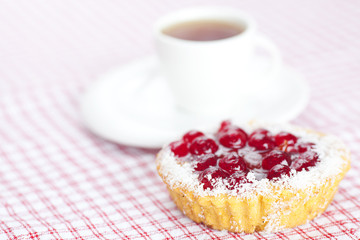 beautiful cake with berries and tea on plaid fabric