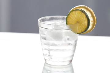 water with lemon and lime in a glass with ice