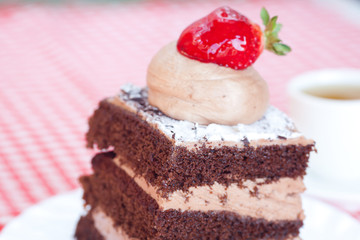 beautiful cake with strawberry and tea on plaid fabric