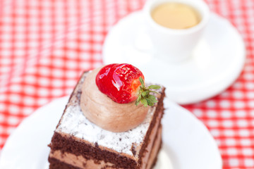 beautiful cake with strawberry and tea on plaid fabric