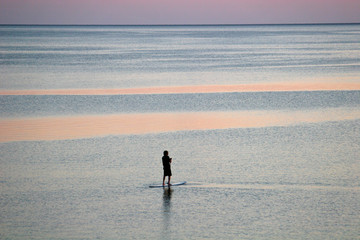 paddle boarder at dusk