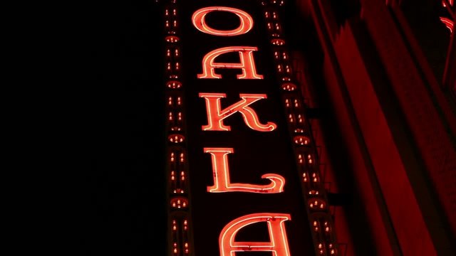 Medium shot of  Downtown Oakland sign in red neon