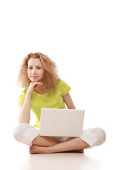 A young girl sitting on the floor with a laptop