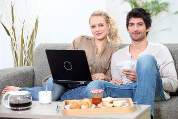 Couple having breakfast with computer