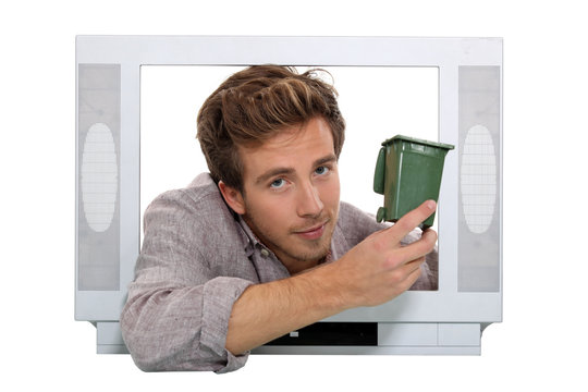 Man holding recycling bin inside television
