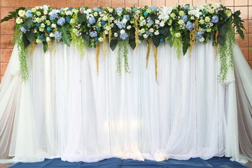 Backdrop flowers over white fabric ready for wedding ceremony.