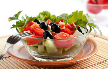 Juicy Greek salad in  glass salad bowl