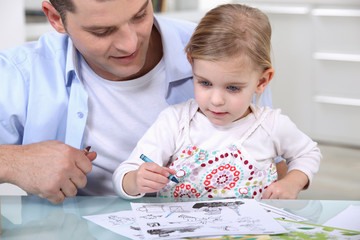 Little girl drawing with father