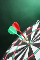 dart board with darts on green background