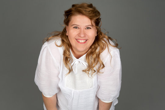 smiling fat woman on gray background