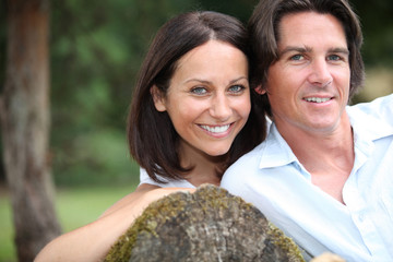 Couple leaning on tree trunk