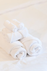 Fototapeta na wymiar bath towels rolled on white bed