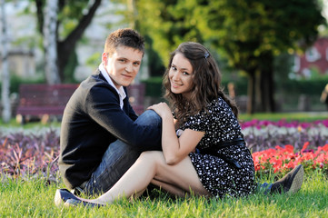 a smiling couple sitting on the grass