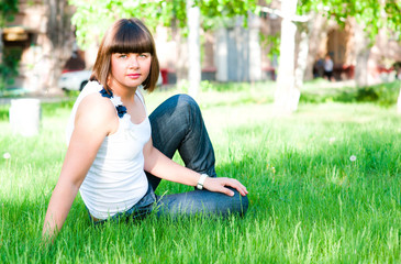 Naklejka na ściany i meble young girl sitting on grass