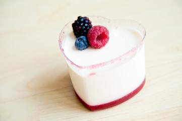 Panna Cotta in heart shape cup on wood pattern background :
