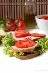tasty sandwich with bacon, tomato and salad