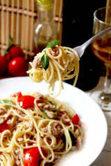 spaghetti with tuna fish and basil in a fork