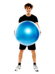 Male fitness trainer holding a pilate ball