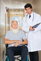 Fototapeta premium Doctor Standing By Patient On Wheel Chair