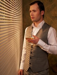 Fototapeta premium Man with a glass near a window.